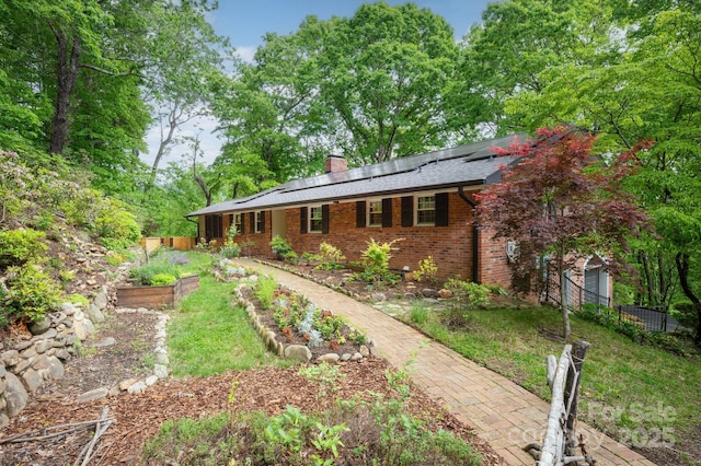 200 Allen Mountain Dr, Black Mountain, NC 28711 - ranch-style home featuring a chimney, a garden, fence, brick siding, and solar panels