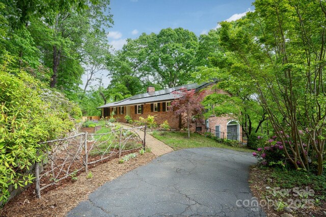 200 Allen Mountain Dr, Black Mountain, NC 28711 - single story home featuring roof mounted solar panels, a chimney, brick siding, and fence
