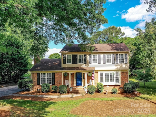 2315 Lawton Bluff Rd, Charlotte, NC 28226 - view of front of house featuring brick siding, a front lawn, covered porch, a chimney, and roof with shingles