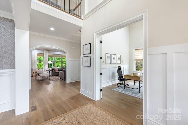 1445 Cherry Laurel Dr, Waxhaw, NC 28173 - entrance foyer featuring arched walkways, a high ceiling, ornamental molding, hardwood / wood-style flooring, and wainscoting