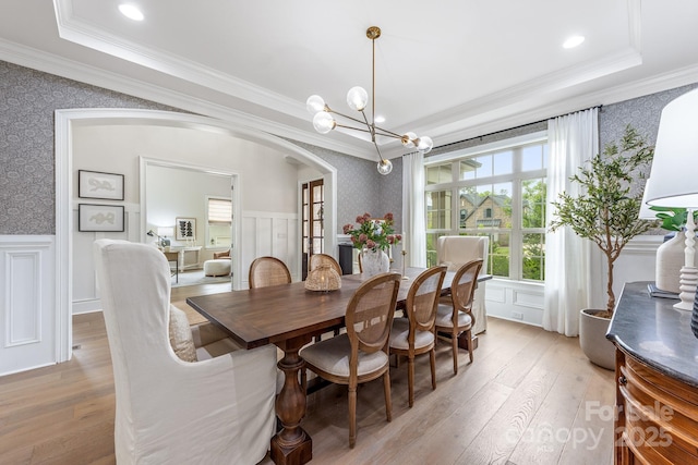 1445 Cherry Laurel Dr, Waxhaw, NC 28173 - dining room featuring wallpapered walls, ornamental molding, a tray ceiling, light wood-style floors, and a wainscoted wall