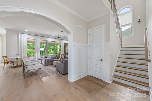 1445 Cherry Laurel Dr, Waxhaw, NC 28173 - foyer entrance featuring light wood finished floors, stairs, arched walkways, and crown molding