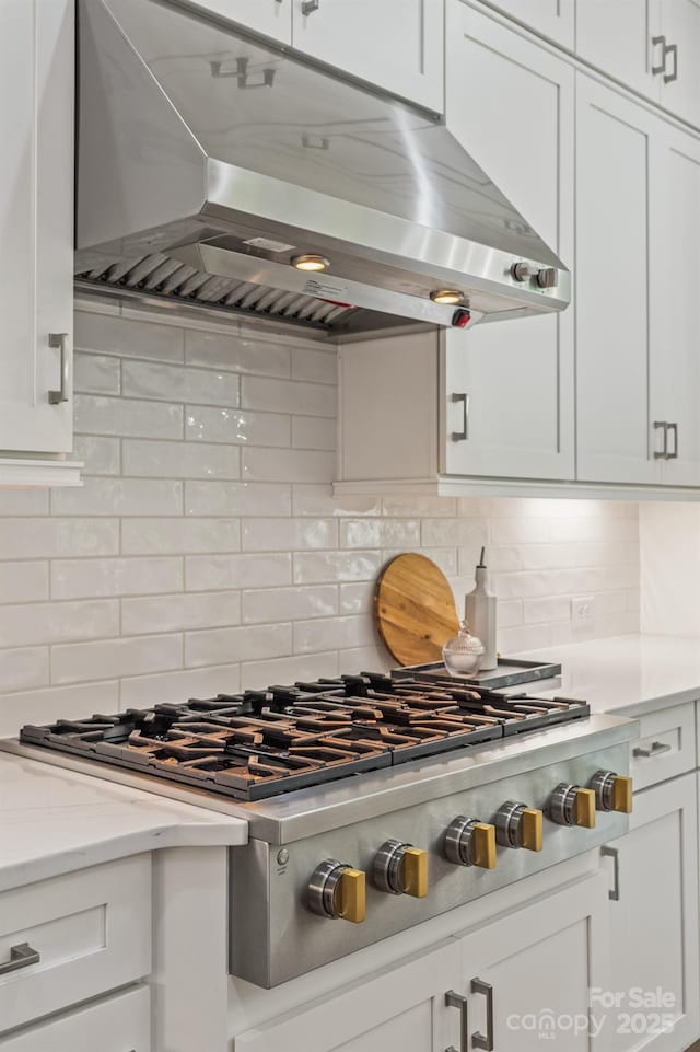 1445 Cherry Laurel Dr, Waxhaw, NC 28173 - kitchen featuring extractor fan, stainless steel gas stovetop, white cabinets, backsplash, and light stone countertops