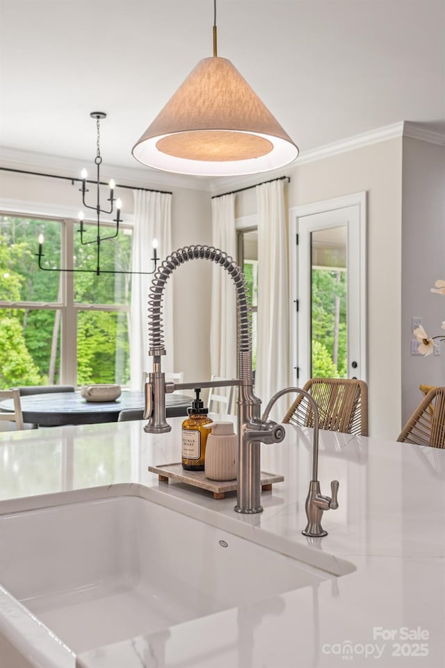 1445 Cherry Laurel Dr, Waxhaw, NC 28173 - kitchen view of a sink, crown molding, light stone counters, hanging light fixtures, and a chandelier