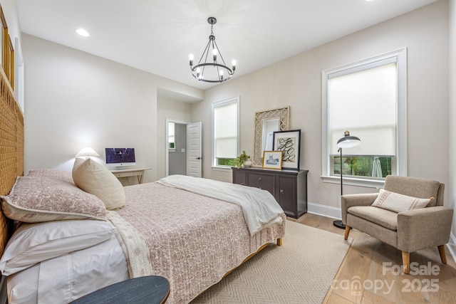 1445 Cherry Laurel Dr, Waxhaw, NC 28173 - bedroom with a chandelier, light wood-style flooring, recessed lighting, and baseboards