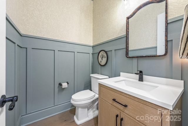 1445 Cherry Laurel Dr, Waxhaw, NC 28173 - half bathroom with a decorative wall, wainscoting, wood finished floors, toilet, and vanity