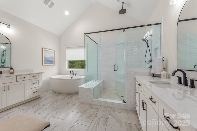 1445 Cherry Laurel Dr, Waxhaw, NC 28173 - full bathroom featuring a shower stall, high vaulted ceiling, a freestanding tub, two vanities, and recessed lighting