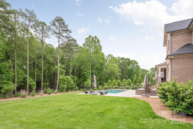 1445 Cherry Laurel Dr, Waxhaw, NC 28173 - view of green lawn featuring an outdoor pool, a patio area, and a wooded view