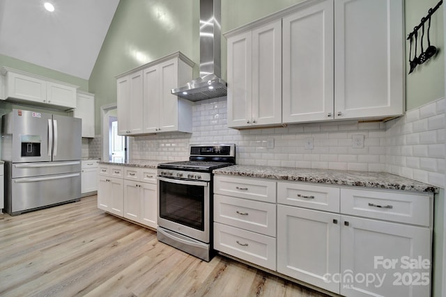 1166 Rocky River Rd, Lancaster, SC 29720 - kitchen with appliances with stainless steel finishes, wall chimney range hood, vaulted ceiling, light wood-type flooring, and backsplash