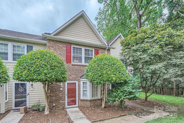 townhome / multi-family property featuring brick siding and fence