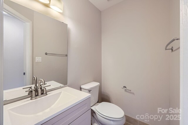 bathroom featuring toilet, vanity, and tile patterned floors