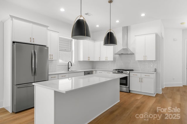2006 St John St, Charlotte, NC 28216 - kitchen featuring appliances with stainless steel finishes, wall chimney range hood, light countertops, white cabinets, and recessed lighting