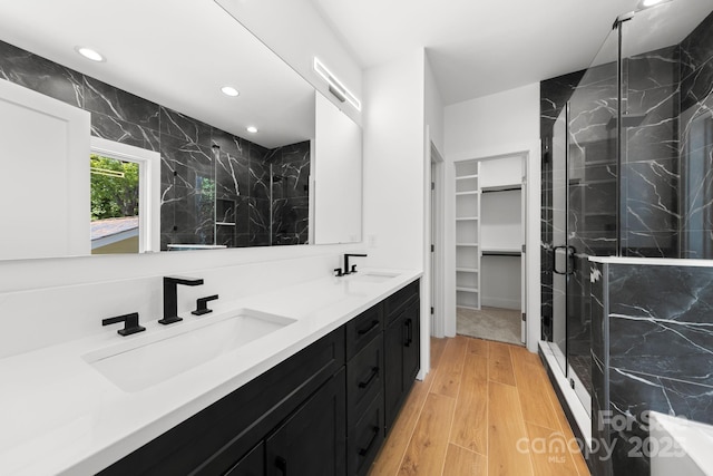 2006 St John St, Charlotte, NC 28216 - full bathroom featuring a marble finish shower, wood finished floors, double vanity, recessed lighting, and a walk in closet