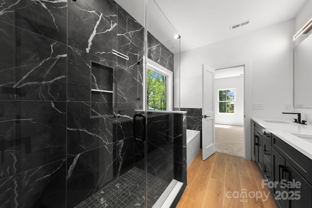 2006 St John St, Charlotte, NC 28216 - full bath featuring wood finished floors, double vanity, a marble finish shower, and a bathtub