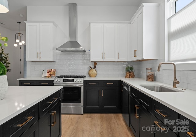 2006 St John St, Charlotte, NC 28216 - kitchen featuring appliances with stainless steel finishes, wall chimney exhaust hood, dark cabinetry, and white cabinets