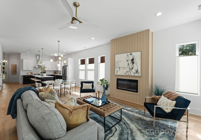 2006 St John St, Charlotte, NC 28216 - living room with a chandelier, a large fireplace, recessed lighting, and light wood-style floors