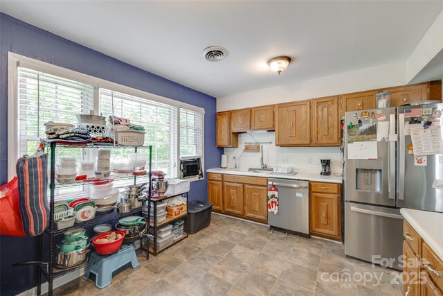 679 Fairforest Rd, Chester, SC 29706 - kitchen featuring brown cabinets, stone finish floor, visible vents, light countertops, and appliances with stainless steel finishes