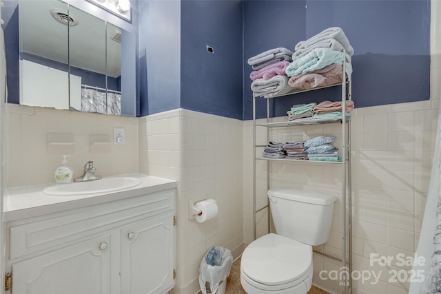 679 Fairforest Rd, Chester, SC 29706 - bathroom with tile walls, toilet, visible vents, vanity, and a wainscoted wall