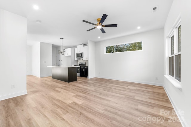 unfurnished living room with ceiling fan, light wood-style floors, recessed lighting, and baseboards