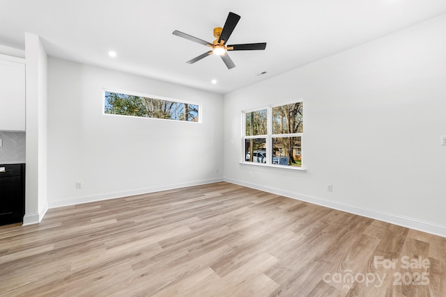unfurnished living room featuring healthy amount of natural light, light wood-style floors, recessed lighting, ceiling fan, and baseboards