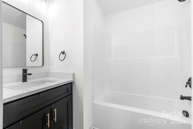 bathroom with vanity, shower / washtub combination, and baseboards