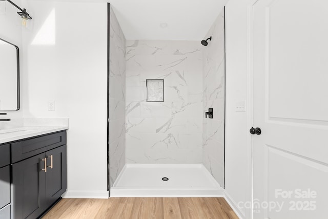 bathroom featuring vanity, a stall shower, and wood finished floors