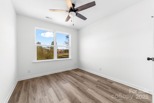 unfurnished room with wood finished floors, baseboards, and ceiling fan