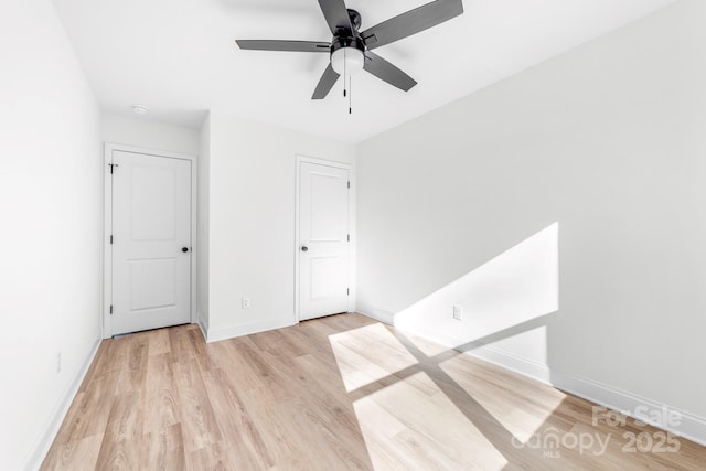unfurnished bedroom with light wood-style floors, baseboards, and a ceiling fan