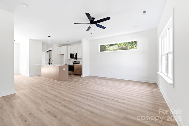 413 Jose St, Shelby, NC 28150 - unfurnished living room featuring a sink, ceiling fan, light wood finished floors, baseboards, and a chandelier