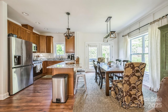 274 Old Bristol Rd, Boone, NC 28607 - kitchen with appliances with stainless steel finishes, brown cabinetry, dark wood-type flooring, light stone counters, and pendant lighting
