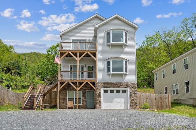 274 Old Bristol Rd, Boone, NC 28607 - view of front of house with stone siding, a balcony, gravel driveway, a garage, and stairway