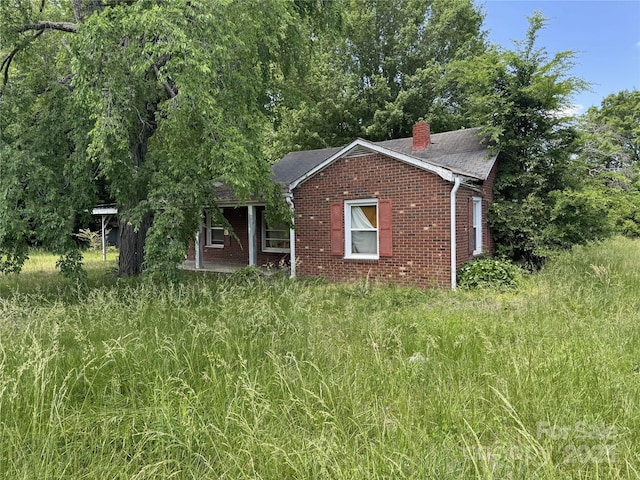 31 Conrad St, Lexington, NC 27295 - view of front of home with brick siding, a chimney, and a shingled roof
