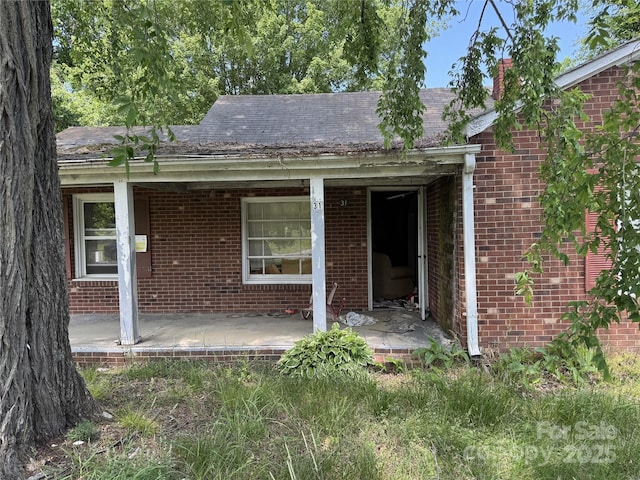 31 Conrad St, Lexington, NC 27295 - view of exterior entry featuring a porch, brick siding, and roof with shingles