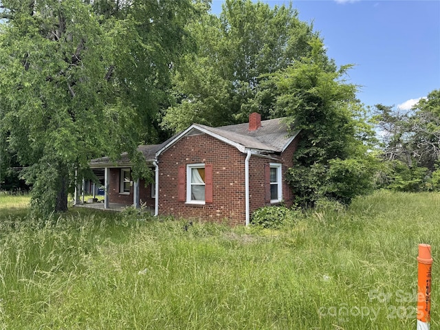 31 Conrad St, Lexington, NC 27295 - view of property exterior featuring brick siding, a chimney, and a shingled roof