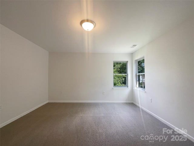 carpeted spare room featuring baseboards