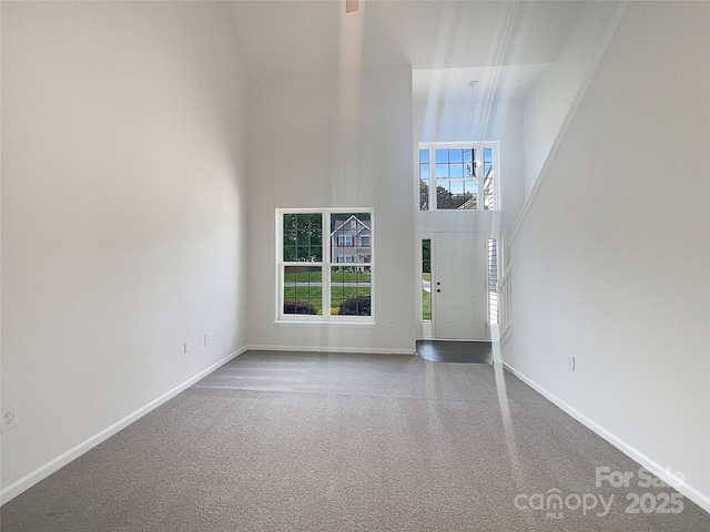 interior space with baseboards and a towering ceiling