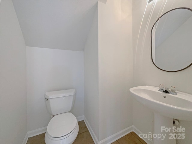 half bathroom with toilet and baseboards