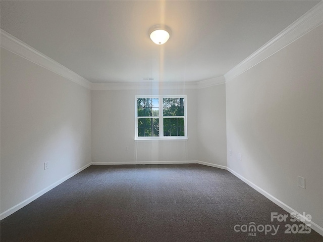 empty room with dark carpet, baseboards, and ornamental molding