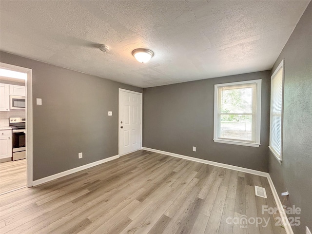 1464 19th Ave NE, Hickory, NC 28601 - spare room with light wood-style floors, a textured ceiling, baseboards, and a smoke detector