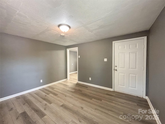 1464 19th Ave NE, Hickory, NC 28601 - spare room featuring wood finished floors, a textured ceiling, and baseboards
