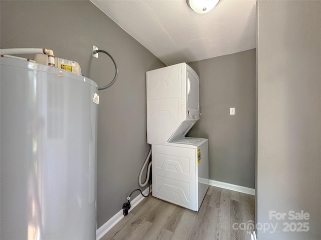 1464 19th Ave NE, Hickory, NC 28601 - laundry area featuring electric water heater, stacked washer and clothes dryer, light wood-style flooring, and baseboards