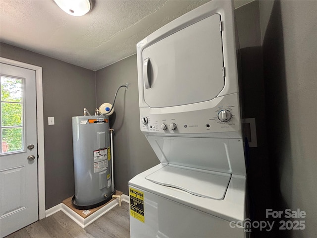 1464 19th Ave NE, Hickory, NC 28601 - laundry area with electric water heater, stacked washer and clothes dryer, light wood-type flooring, baseboards, and a textured ceiling