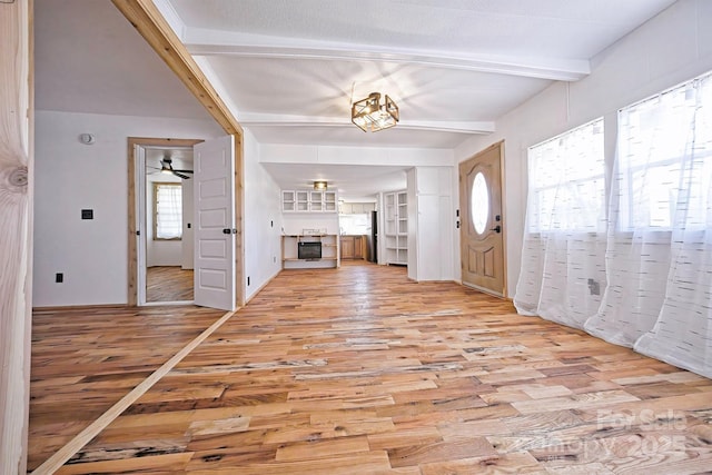 entrance foyer with ceiling fan, beam ceiling, and light wood-type flooring