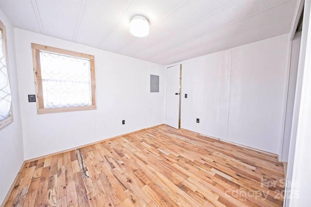 unfurnished room featuring electric panel and light wood-type flooring