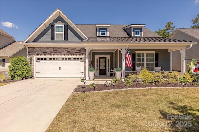 view of front of property with a standing seam roof, a front yard, driveway, a porch, and metal roof