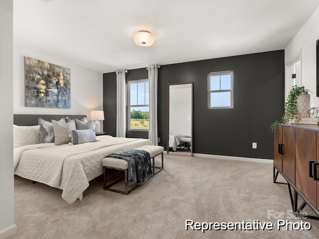 bedroom with baseboards, multiple windows, and light colored carpet