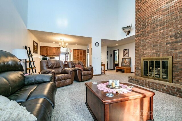 living area with light carpet, a high ceiling, a chandelier, and a brick fireplace