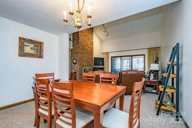 dining space with light colored carpet, a chandelier, rail lighting, and baseboards