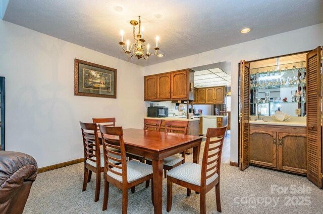 dining space featuring a chandelier, light carpet, baseboards, and recessed lighting