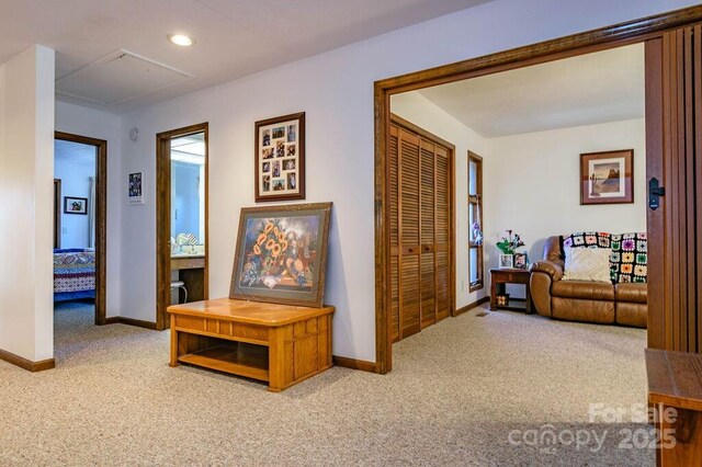 hallway featuring carpet flooring, baseboards, attic access, and recessed lighting